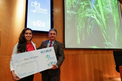  A autora da fotografia “Água que alimenta o mundo”, Lilian, recebeu o prêmio do vice-presidente diretor da CNA, Mário Borba.